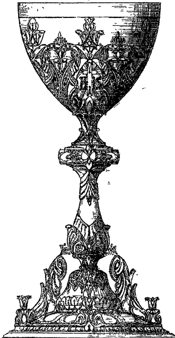 A detailed black and white illustration of an ornate chalice. The bowl is decorated with intricate floral and foliate patterns. The stem is slender and features decorative elements, including a small cross-like motif. The base is wide and also decorated with floral and foliate designs, ending in small feet.